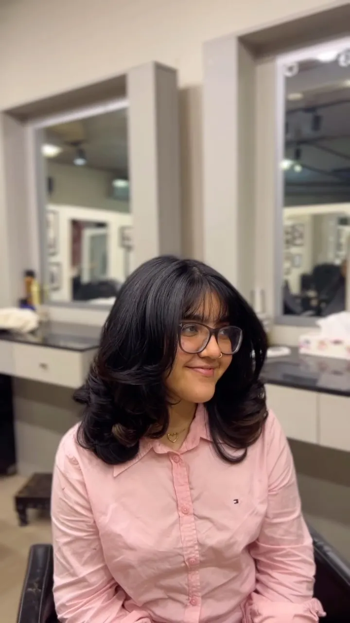 Layered cut with curtain bangs and a soft, rounded finish
