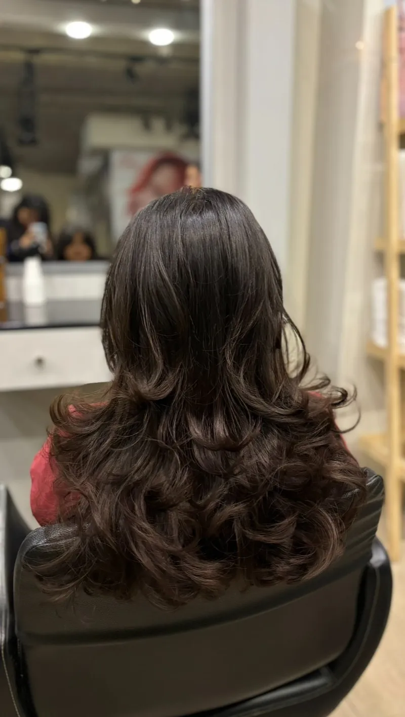 Back view of long brunette hair blow-dried into soft waves